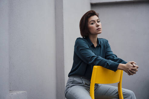 Selbstbewusste junge Geschäftsfrau auf einem Stuhl sitzend - JOSEF16063