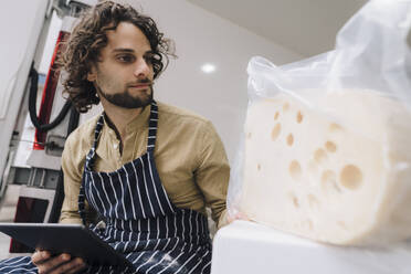 Junger Geschäftsmann mit Tablet-PC, der Käse im Lieferwagen untersucht - JOSEF16139