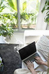 Freelancer working on laptop in living room - SVKF01114