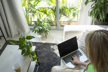 Freiberufler mit Laptop im Wohnzimmer im Home Office - SVKF01115