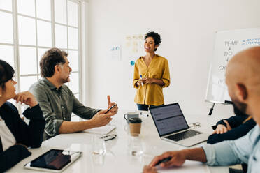 Eine Gruppe verschiedener Geschäftsleute, die in einer Sitzung diskutieren. Multikulturelle Geschäftsleute, die in einem Sitzungssaal ein Projekt planen. Ein kreatives Team, das in einem Büro zusammenarbeitet. - JLPSF29037