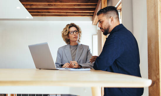 Professionelle Geschäftsleute, die in einem Büro über ein Projekt sprechen. Reife Geschäftsleute, die ihre Arbeitsabläufe und Fortschritte diskutieren. Treffen zwischen zwei Geschäftskollegen. - JLPSF29144