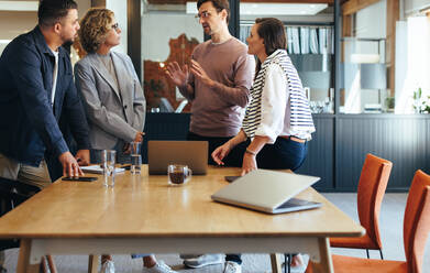 Creative business people having a discussion in a meeting. Group of business people planning a project in an office. Teamwork and collaboration in a digital marketing agency. - JLPSF29162