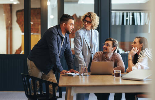 Ein Team von Fachleuten bei einer Besprechung in einer Agentur für digitales Marketing. Geschäftsleute, die ein Projekt in einem Büro besprechen. Teamarbeit und Zusammenarbeit an einem kreativen Arbeitsplatz. - JLPSF29166