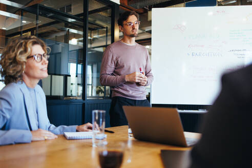 Geschäftsleute planen ein Projekt in einem Büro. Eine Gruppe von Geschäftsleuten diskutiert in einer Besprechung. Teamarbeit und Zusammenarbeit in einem Startup-Unternehmen. - JLPSF29181