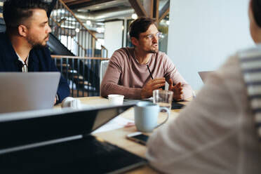 Business meeting in a marketing agency. Group of creative business people having a discussion over a project. Business team working together in an office. - JLPSF29262