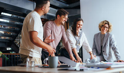 Erfolgreiches Team, das in einer Werbeagentur an einem Projekt arbeitet. Gruppe von Geschäftsleuten, die in einer Sitzung ein Brainstorming durchführen. Geschäftsleute, die mit Hilfe von Haftnotizen Ideen diskutieren. - JLPSF29269