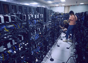 Technicians working in server room - TETF01859