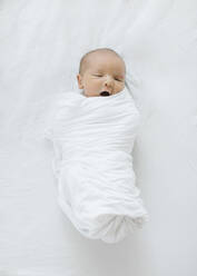 Draufsicht auf einen neugeborenen Jungen (0-1 Monate), der in eine Decke gewickelt ist - TETF01927