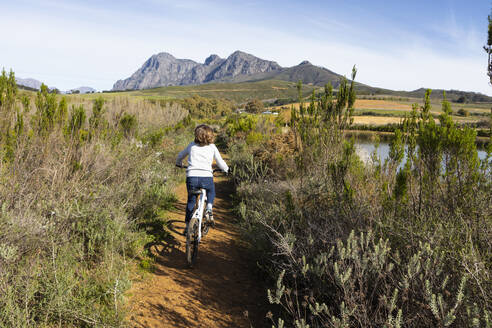 Südafrika, Stellenbosch, Rückansicht eines Jungen (8-9) während einer Fahrradtour - TETF01929