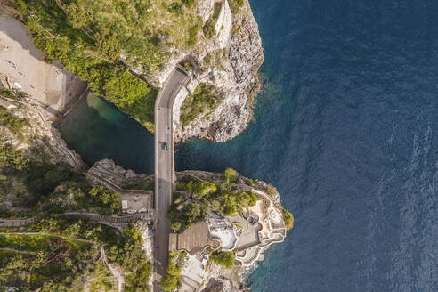 Luftaufnahme eines Autos, das über die Brücke fährt, die den Fjord in Furore überquert, einer kleinen Stadt an der Amalfiküste, Salerno, Kampanien, Italien. - AAEF17203