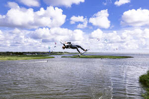 Luftaufnahme eines Kiteboarders bei einer Kiteloop-Backroll hoch in der Luft, Svencele, Litauen. - AAEF17233