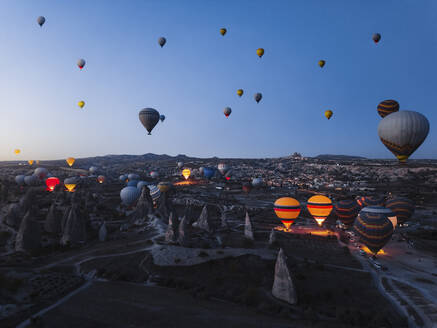 Luftaufnahme von Heißluftballons bei Sonnenaufgang in Kappadokien, Türkei. - AAEF17249