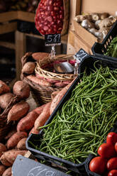 Von oben grüne Bohnen, Süßkartoffeln und Tomaten an einem Stand auf dem örtlichen Markt - ADSF42761