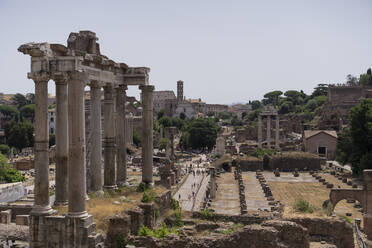 Ruins of Temple of Saturn located against cloudless sky on famous Roman Forum in daytime in Rome, Italy - ADSF42773