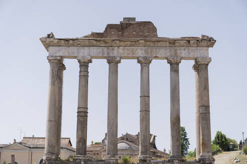 Ruinen des Saturntempels vor wolkenlosem Himmel auf dem berühmten Forum Romanum bei Tag in Rom, Italien - ADSF42774
