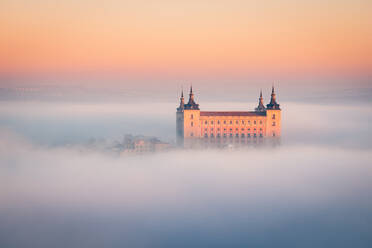 Von oben wunderbare Landschaft der mittelalterlichen Burg über Stadt in nebligen bunten Sonnenaufgang umgeben von Wolken gebaut - ADSF42856