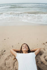 Unbekümmerte Frau entspannt sich in der Nähe des Ufers am Strand - JOSEF16171