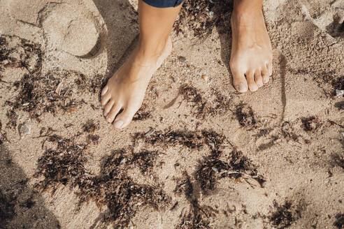 Frau steht barfuß auf Sand am Strand - JOSEF16178