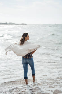 Frau mit Kopftuch im Meer stehend am Strand - JOSEF16183