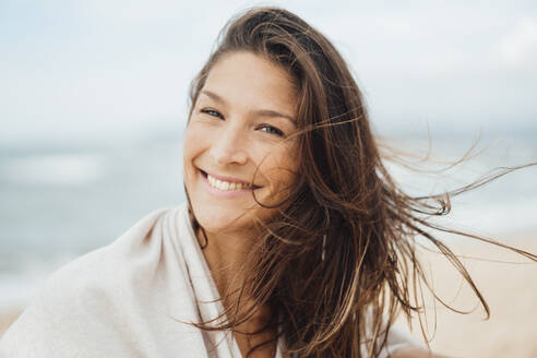 Cheerful brunette woman at beach - JOSEF16211