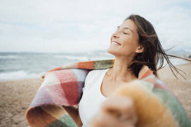 Lächelnde Frau mit geschlossenen Augen verbringt ihre Freizeit am Strand - JOSEF16217