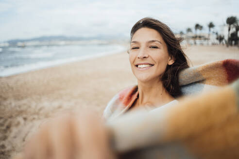 Smiling woman spending leisure time at beach - JOSEF16218