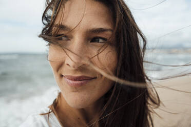 Nachdenkliche Frau lächelt am Strand - JOSEF16226