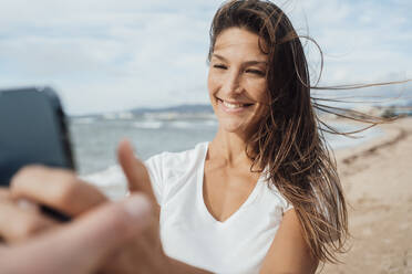 Glückliche Frau nimmt Selfie durch Handy am Strand - JOSEF16242