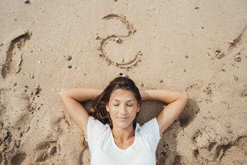 Frau mit geschlossenen Augen schlafend auf Sand am Strand - JOSEF16263