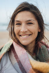 Happy brunette woman with scarf at beach - JOSEF16270