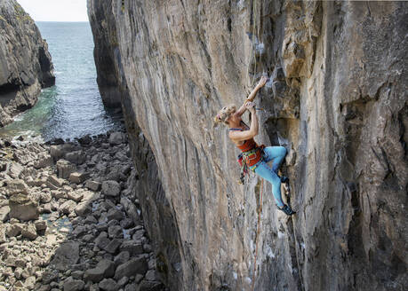 Reife abenteuerlustige Frau klettert auf felsigem Berg - ALRF01911