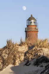 Germany, Mecklenburg-Vorpommern, Sand dune in front of Darsser Ort Natureum lighthouse at dusk - KEBF02597