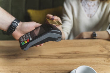 Woman making payment through credit card at cafe - OSF01363