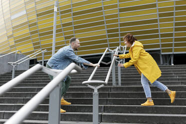 Glückliches Paar spielt auf der Treppe vor dem Stadion - VIVF00321