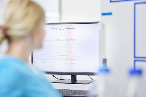 Wissenschaftlerin und Testergebnisse auf einem Computerbildschirm in einem Labor - CVF02253