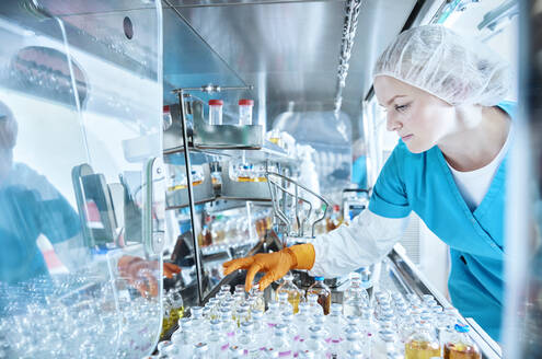 Female scientist working in cleanroom of a microbiological lab - CVF02254