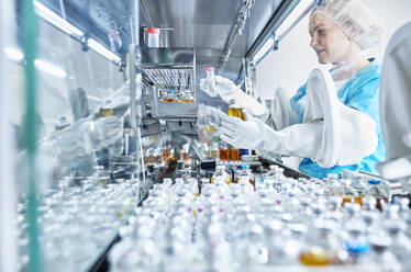 Female scientist working in cleanroom of a microbiological lab - CVF02255