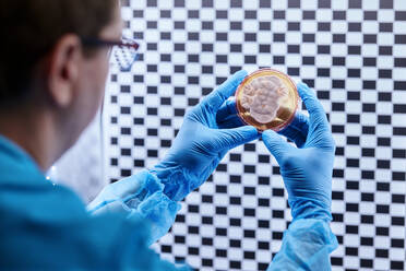 Scientist holding petri dish in a microbiological lab - CVF02268