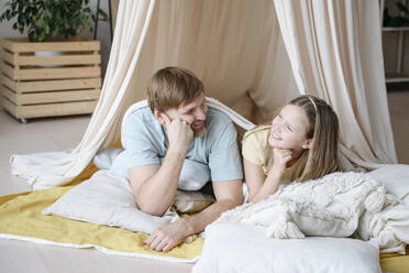 Happy father and daughter in tent at home - EYAF02535