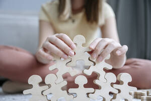 Mädchen spielt mit Holzpuzzle zu Hause - EYAF02545