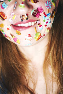 Frau mit Aufklebern im Gesicht beißt auf Lippe - SVCF00305