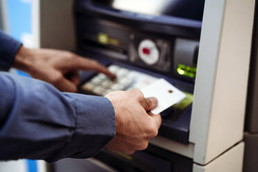 Businessman with credit card using ATM machine - EBBF07787