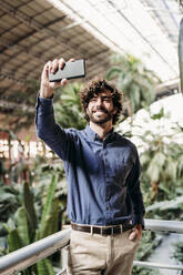Glücklicher Geschäftsmann, der ein Selfie mit seinem Smartphone macht - EBBF07806