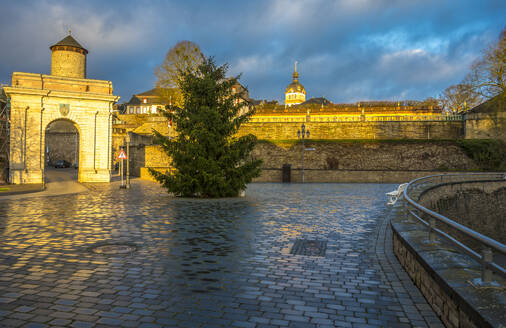 Weilburg Castle with gate and Christmas tree under cloudy sky at sunrise - MHF00711