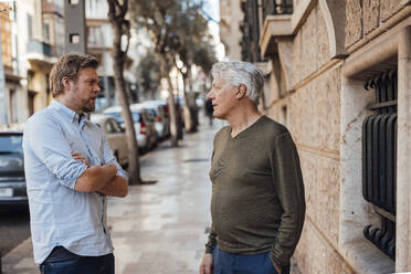Älterer Mann im Gespräch mit seinem Vater auf dem Fußweg stehend - JOSEF16318