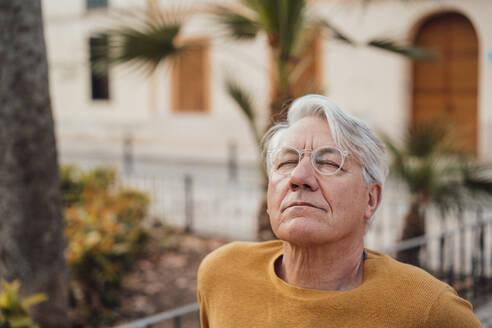 Älterer Mann mit geschlossenen Augen vor einem Gebäude - JOSEF16356