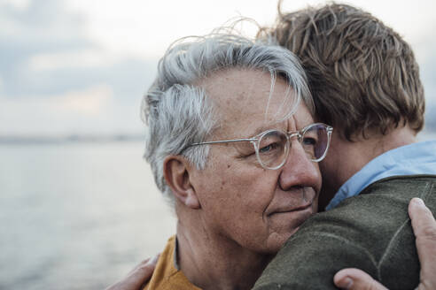 Älterer Mann mit grauem Haar, der seinen Sohn umarmt - JOSEF16396