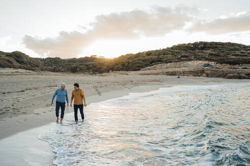 Man enjoying with father on beach at sunset - JOSEF16476