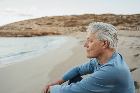 Nachdenklicher älterer Mann sitzt bei Sonnenuntergang am Strand - JOSEF16488